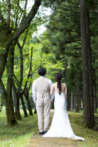 富山の頼成の森で森林の中佇むドレス姿の新郎新婦の前撮りフォトウェディング