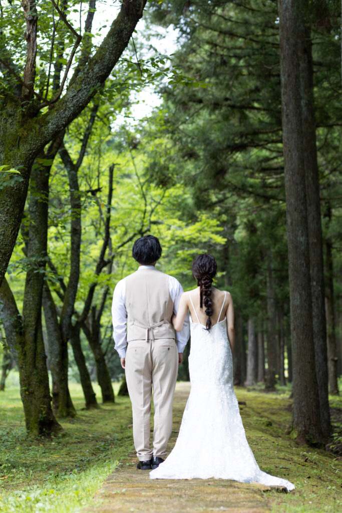 森林の中でフォトウェディングをする新郎新婦