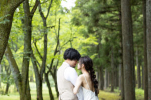富山の頼成の森で森林の中寄り添うドレス姿の新郎新婦の前撮りフォトウェディング