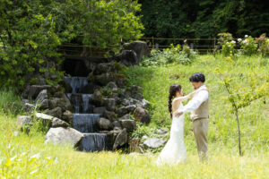 富山の頼成の森で森林の中寄り添うドレス姿の新郎新婦の前撮りフォトウェディング