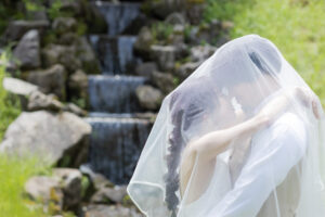 富山の頼成の森で森林の中寄り添うドレス姿の新郎新婦の前撮りフォトウェディング