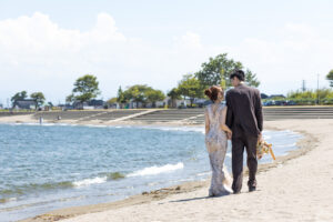 富山の海老江海浜公園で洋装ロケーションフォトウェディングを行う新郎新婦の前撮り写真