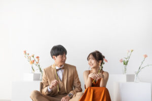 富山のフォトスタジオでテラコッタカラーのドレスを着てフォトウェディングを行う洋装新郎新婦の前撮り写真