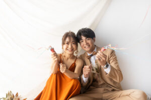富山のフォトスタジオでテラコッタカラーのドレスを着てフォトウェディングを行う洋装新郎新婦の前撮り写真