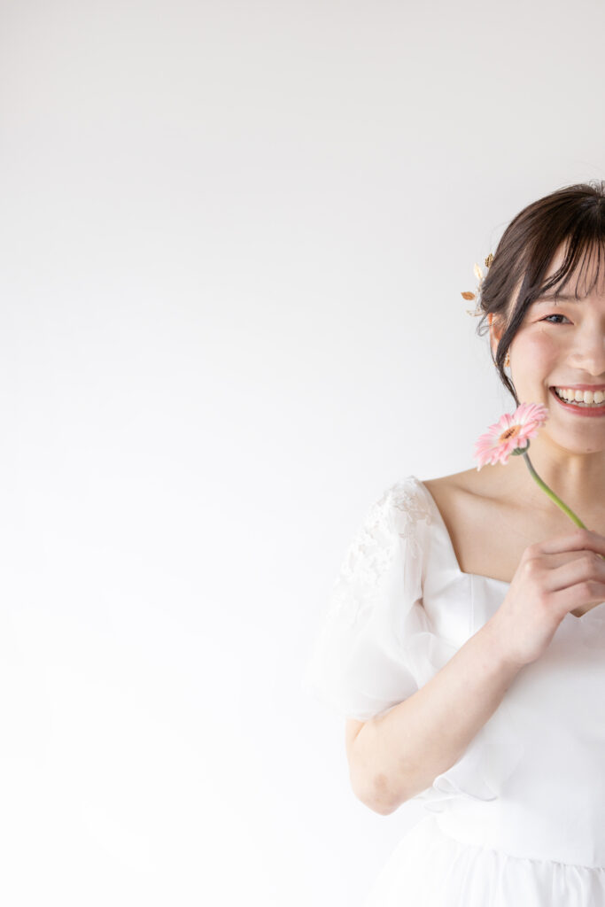 ピンクの花を持って微笑む花嫁