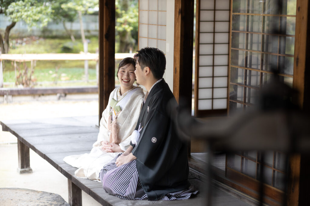 縁側で楽しく会話をする和装新郎新婦