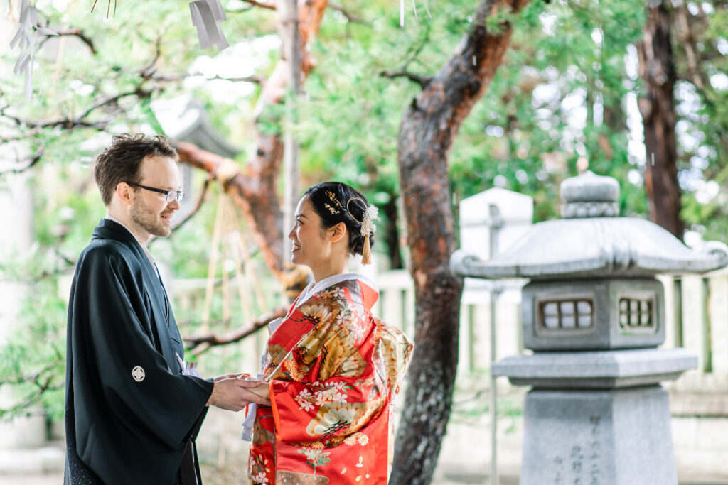 日本庭園で手を取り合う和装新郎新婦