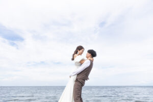 富山の海老江海浜公園で洋装ロケーションフォトウェディングを行う新郎新婦の前撮り写真