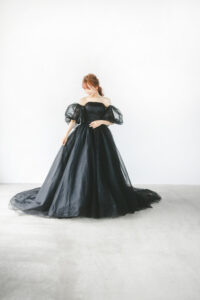 富山のフォトウェディングでシンプルな白いスタジオで黒のパフスリーブドレスを着てポーズをとる洋装花嫁