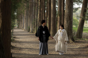 立山寺の並木道で手を繋いで歩く和装姿の新郎新婦のロケーションフォトウェディング