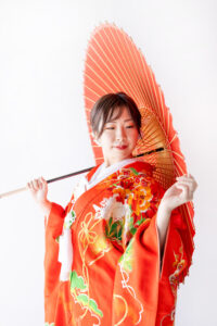 富山のフォトスタジオで撮影した色打掛和装姿の新婦の赤い和傘を持ったフォトウェディング