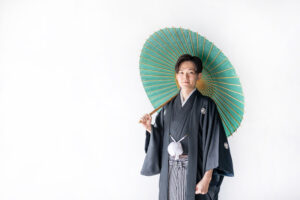 和傘を持った黒紋付袴の和装新郎の富山のスタジオフォトウェディング