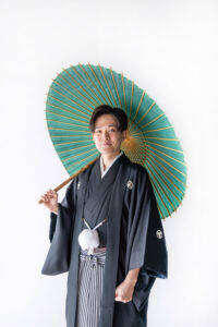 和傘を持った黒紋付袴の和装新郎の富山のスタジオフォトウェディング