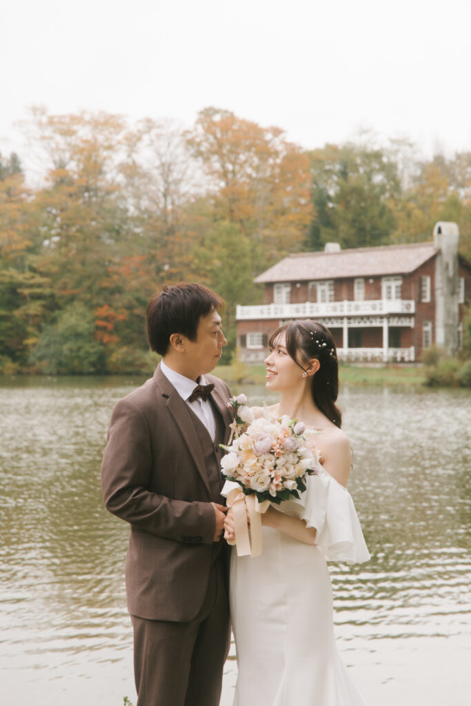 軽井沢の湖で新郎と新婦が向かい合ってブーケを持っているフォトウエディング
