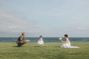 海で子供が花嫁にブーケを渡す富山のロケーションフォトウェディング