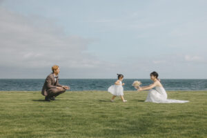 海で子供が花嫁にブーケを渡す富山のロケーションフォトウェディング