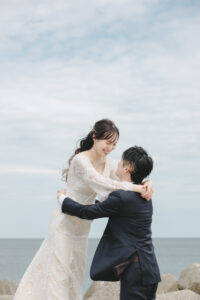 富山の海老江海浜公園で抱き合う洋装新郎新婦のロケーションフォトウェディング