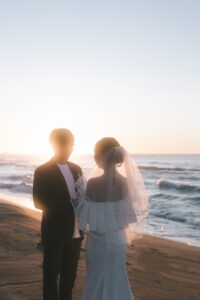 富山のドレスショップコアラが石川県加賀市の片野海水浴場で夕日ロケーションフォトウェディングをしている洋装新郎新婦の前撮り写真