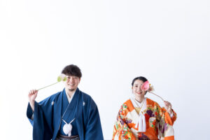 富山のフォトウェディングスタジオで和装の新郎新婦が生花を持って微笑んでいる様子