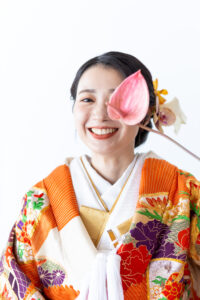 富山のスタジオで生花を持って笑う色打掛、和装の花嫁のソロフォトウェディング