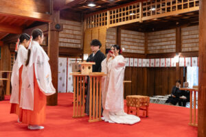 富山の護国神社で神前式をする白無垢と黒紋付袴の2人の写真