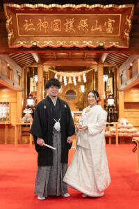富山の護国神社で神前式をする白無垢と黒紋付袴の2人の写真