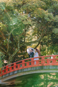 富山の城址公園の赤い橋の上で和装ロケーションフォトウェディングを行う新郎新婦の前撮り写真