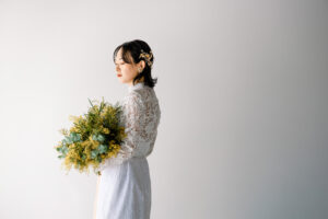 富山のコアラがミモザのブーケを持っている花嫁のソロショットを撮影している富山フォトウェディング