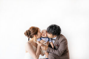 富山のコアラで新郎新婦が我が子にキスをする3人でのファミリーフォトウェディング