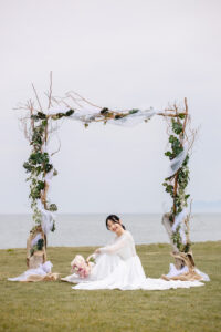 富山のコアラで海老江海岸で花嫁が座って微笑んでいる富山フォトウェディング