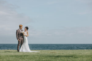 富山のコアラが海で見つめあっている新郎新婦を撮影している様子