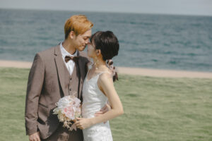 富山のコアラが海で見つめあって鼻キスをしている新郎新婦を撮影している様子