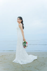 富山のコアラで海で白いドレスを着て撮影している花嫁