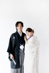 富山のコアラで和装フォトウェディングを行なっている新郎新婦が新郎の肩に手をついて撮影している様子