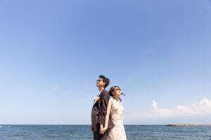 富山のコアラで洋装フォトウェディングを行なっている新郎新婦がサングラスをかけて空を見上げている