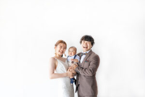富山のコアラで洋装スタジオフォトウェディングを行なっている新郎新婦と赤ちゃんの撮影