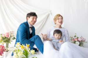 富山のコアラで洋装スタジオフォトウェディングを行なっている新郎新婦と赤ちゃんの撮影