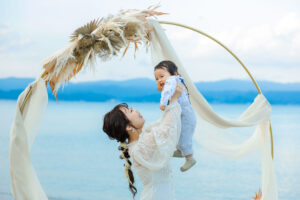 富山のコアラで花嫁と子供2人で海で高い高いをしているフォトウェディング
