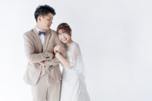 富山のコアラがスタジオで洋装フォトウェディングを行なった新郎新婦が腕を組んでいる様子