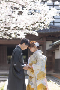 富山のコアラで和装フォトウェディングを桜と共に行いおでこを寄せ合っている新郎新婦の様子